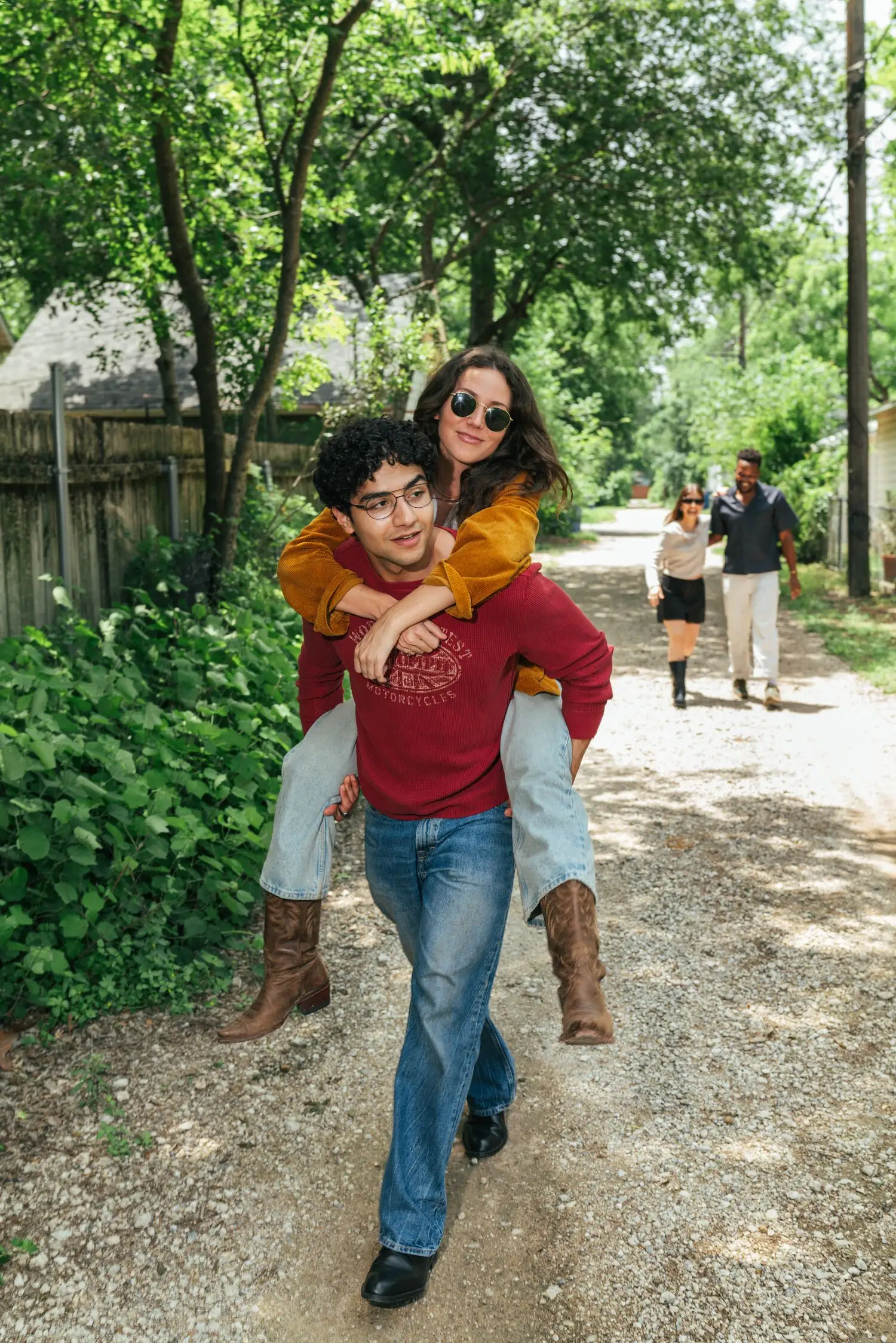 A young couple piggyback through a sun-dappled North Loop alley
